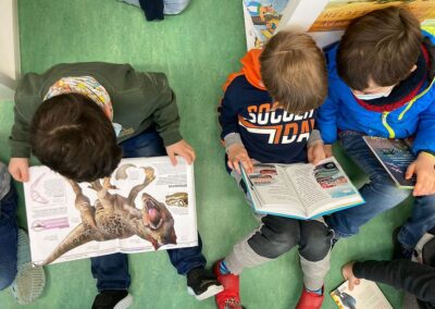 3 Kinder lesen Bücher über z.B. Dinosaurier